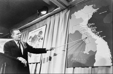 McNamara señalando el mapa de Vietnam en una conferencia de prensa.