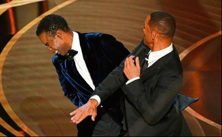 TOPSHOT - US actor Will Smith (R) slaps US actor Chris Rock onstage during the 94th Oscars at the Dolby Theatre in Hollywood, California on March 27, 2022. (Photo by Robyn Beck / AFP)