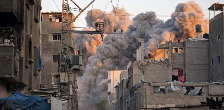 El humo asciende a través de los escombros de un edificio destruido en el campo de refugiados de Bureij, en Gaza