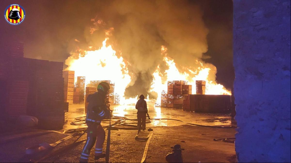 Dos bomberos heridos en el espectacular incendio de una fábrica en la Pobla de Vallbona