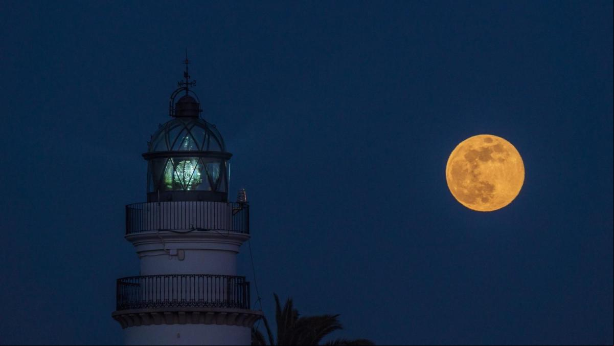 La luna llena ilumina el faro de Calella