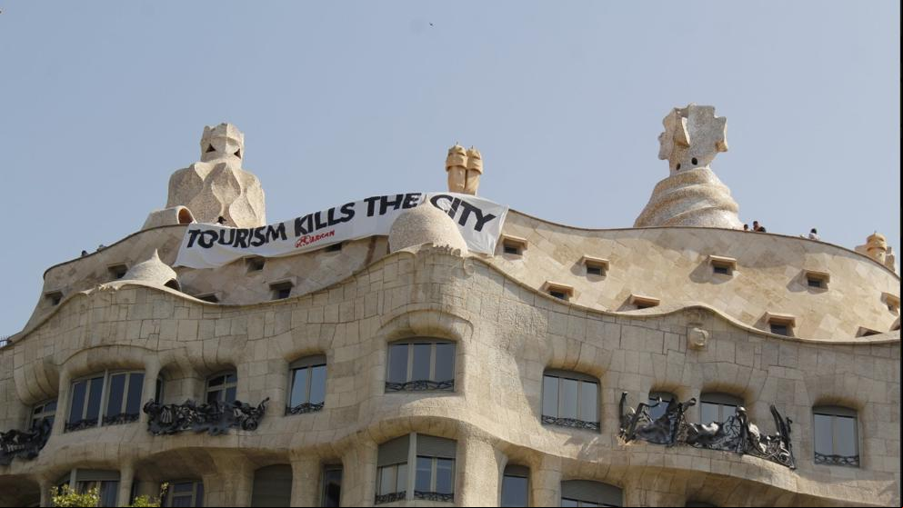 Arran cuelga una pancarta en la Pedrera contra el turismo