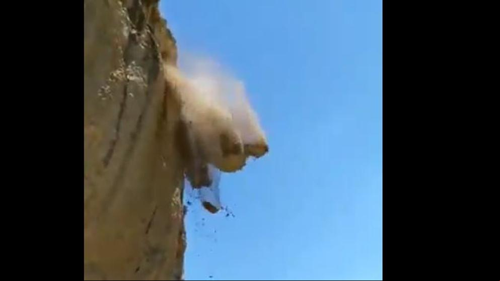 Unos turistas cruzan una carretera cerrada durante unas voladuras de rocas